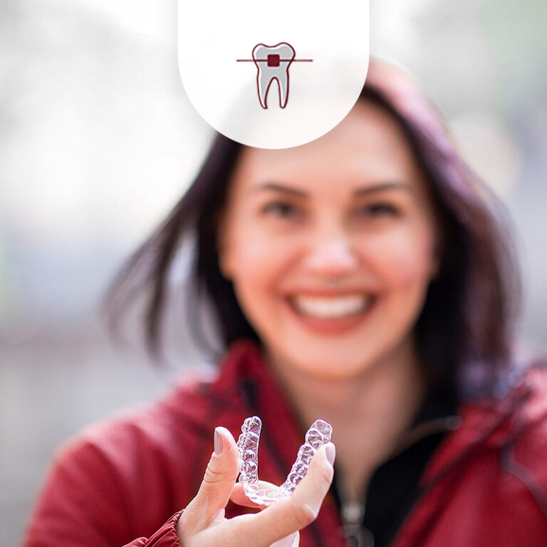 Frau unterwegs, hält Aligner in der Hand